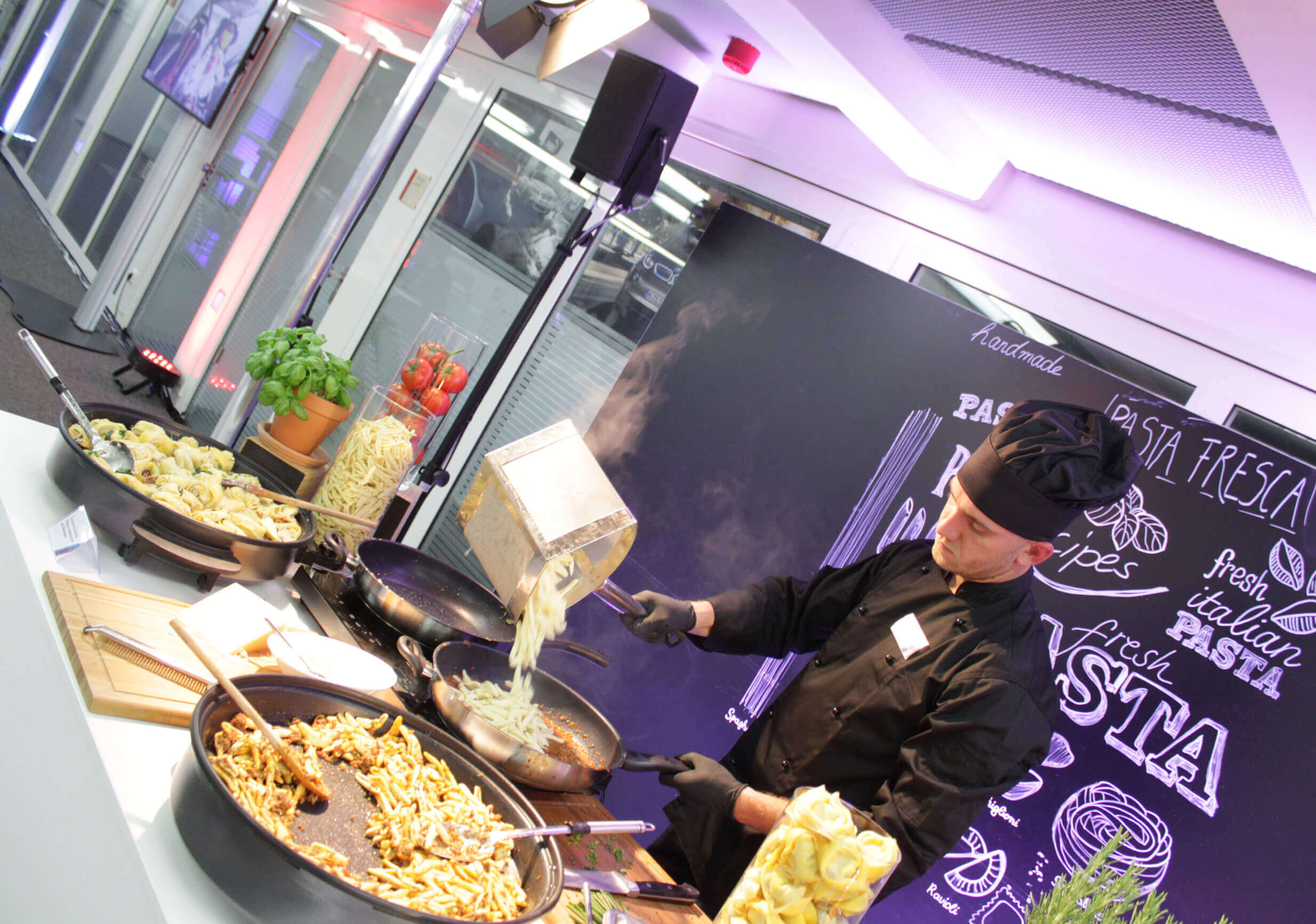 Cook preparing pasta in a mobile event location