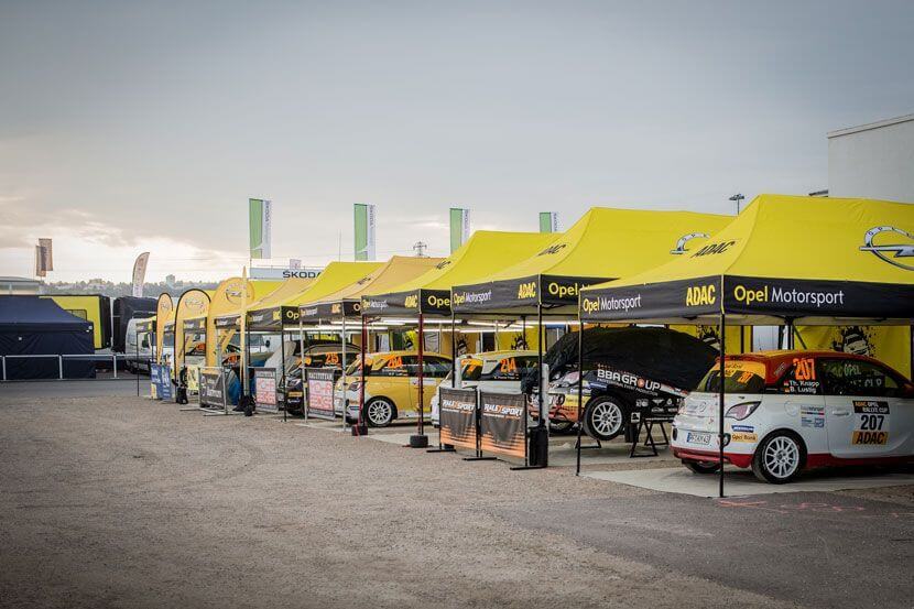 Race cars under tents at ADAC's race