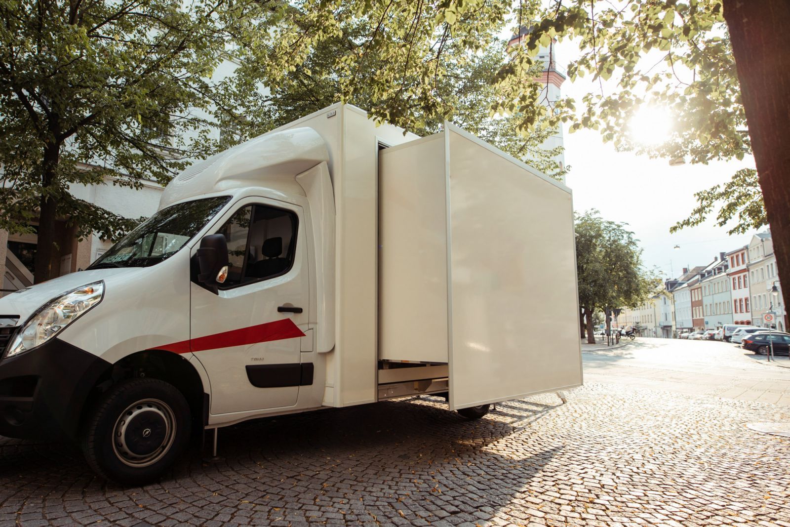 Der AK-Promo-Tourer fährt über eine Straße mit Gegenlicht.